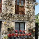 Altes Haus mit Blumen vor den Fenstern in Beget