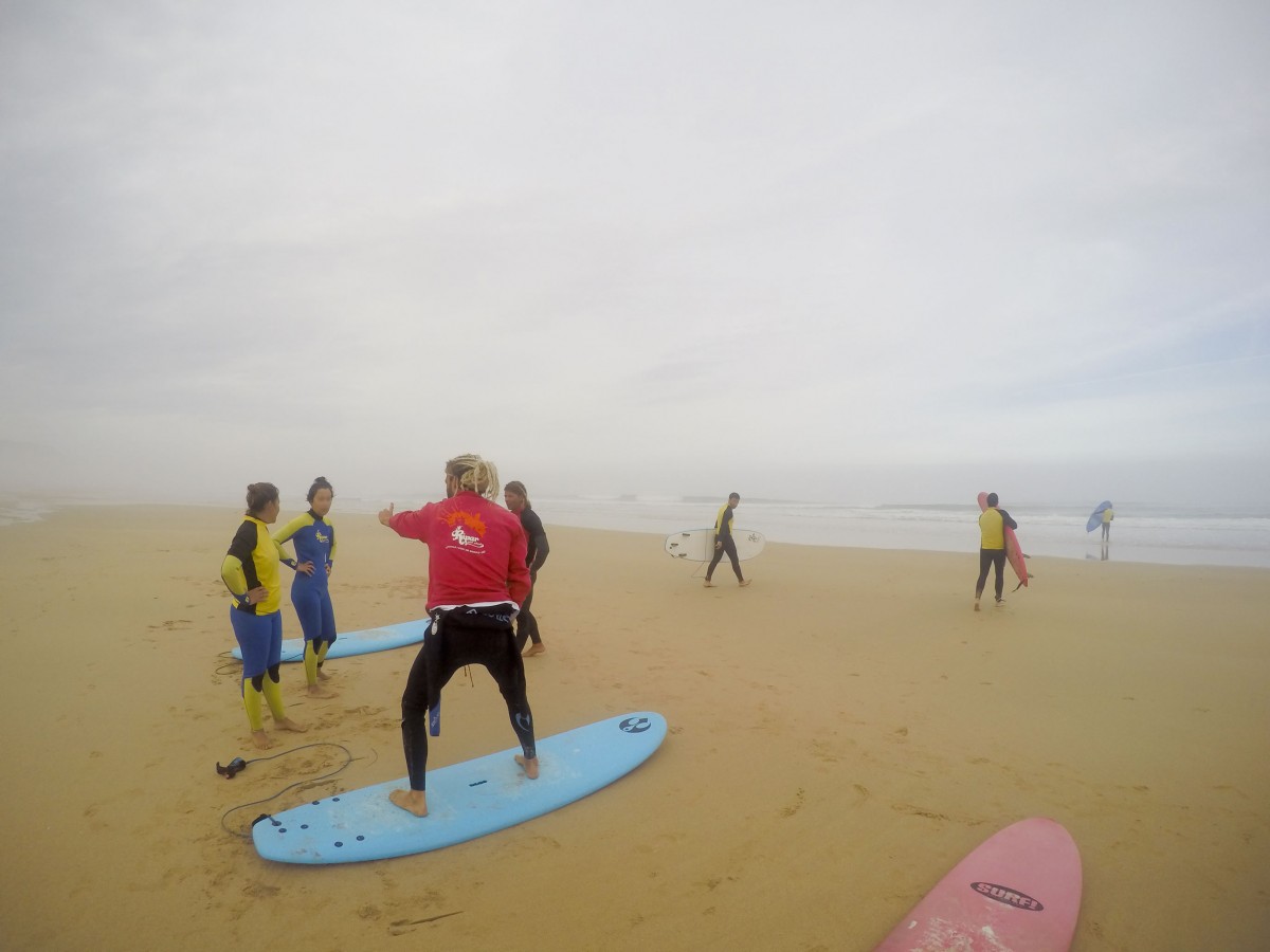 Der Surflehrer zeigt, wie man auf dem Brett steht