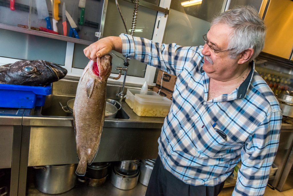 Mann hält Fisch hoch 