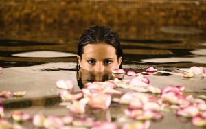 Frau im Pool mit Blüten Spa