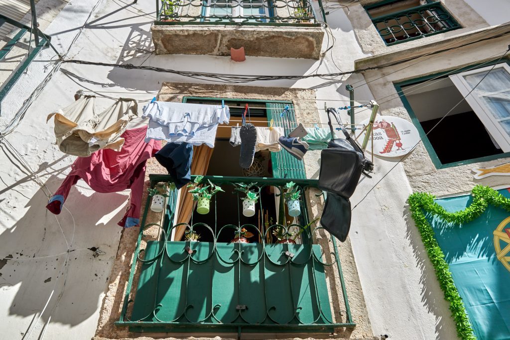 Wäsche trocknet aus dem Fenster raus an Leinen. Alfama Lissabon