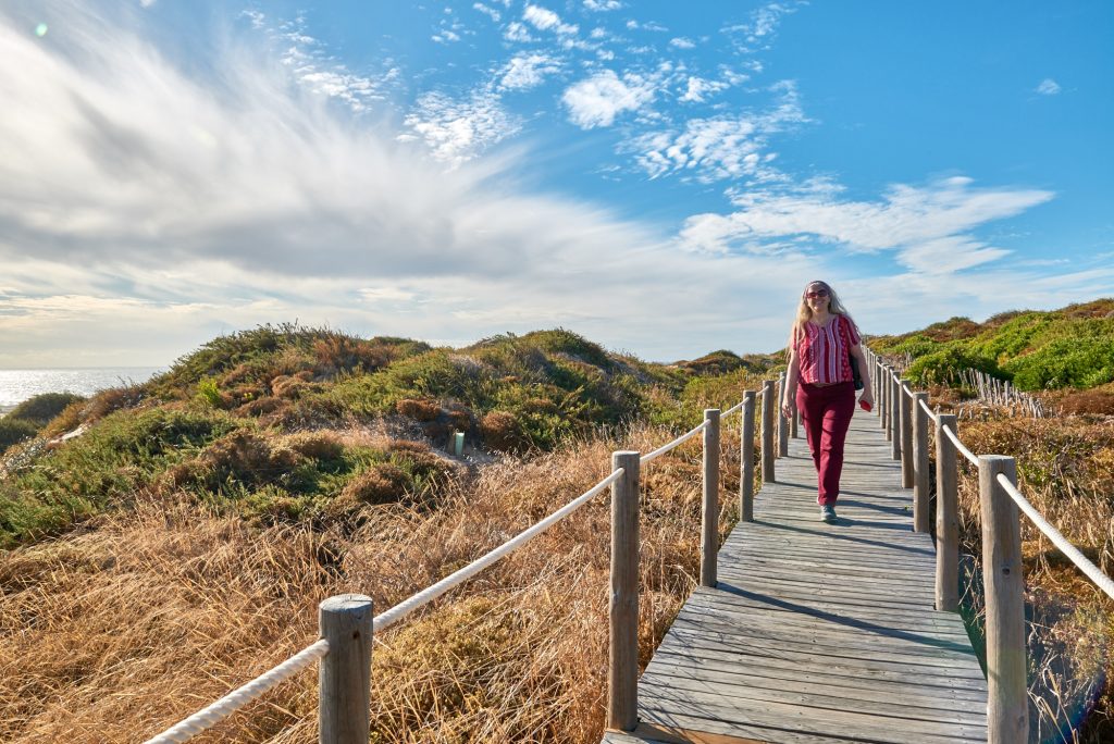 Frau auf Holzweg am Strand