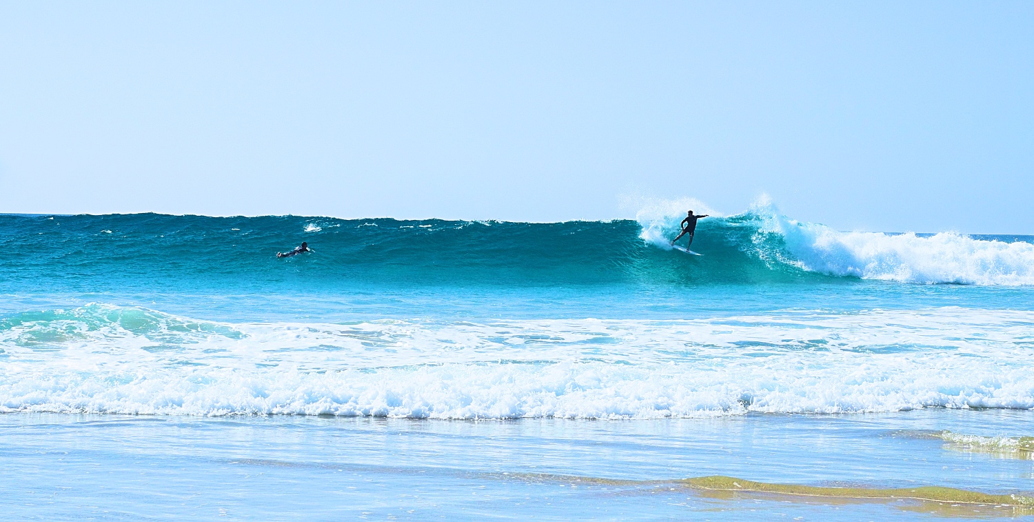 Surfer spielen in Wellen vor Fuerteventura