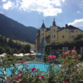 Blick auf Pool, Garten und Fassade Adler Dolomiti Spa Hotel