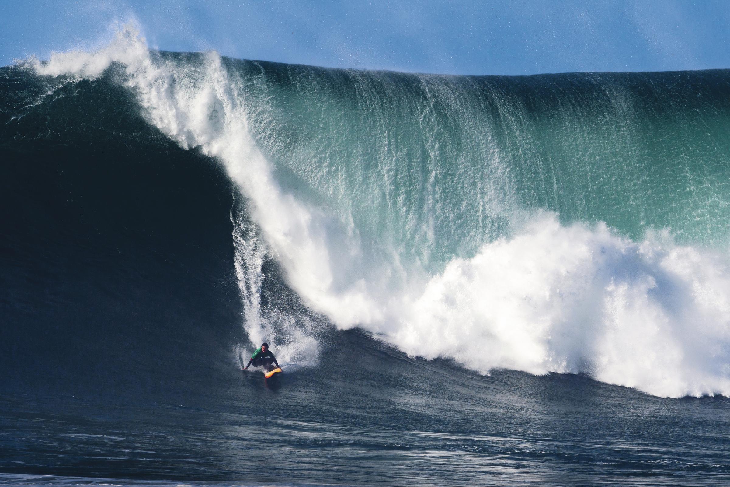 Surfer und Big Wave in Nazaré