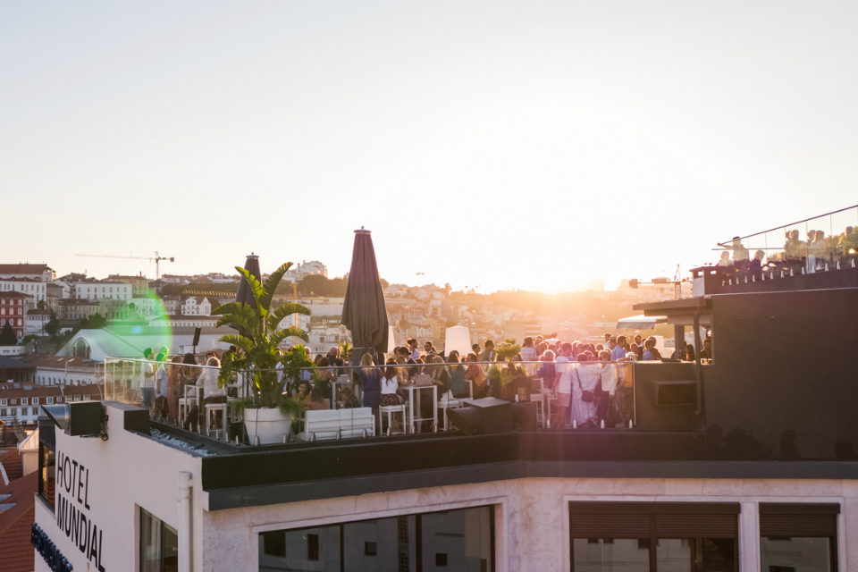 Überfüllte Dachterrasse im Licht des Sonnenuntergangs 