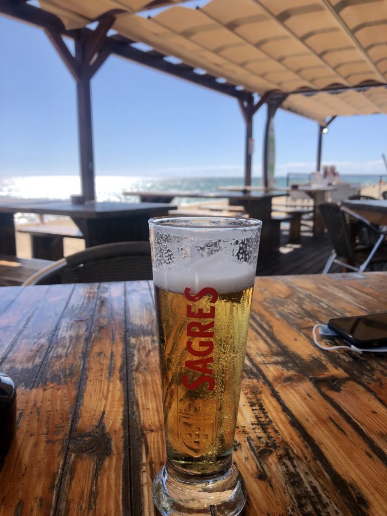Ein kaltes Bier in der der Außengastronomie direkt am Strand - Blick auf das Meer 