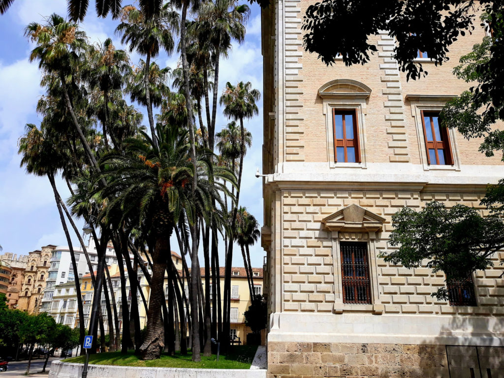 Fassade eines Hauses mit Palmen direkt nebenan 