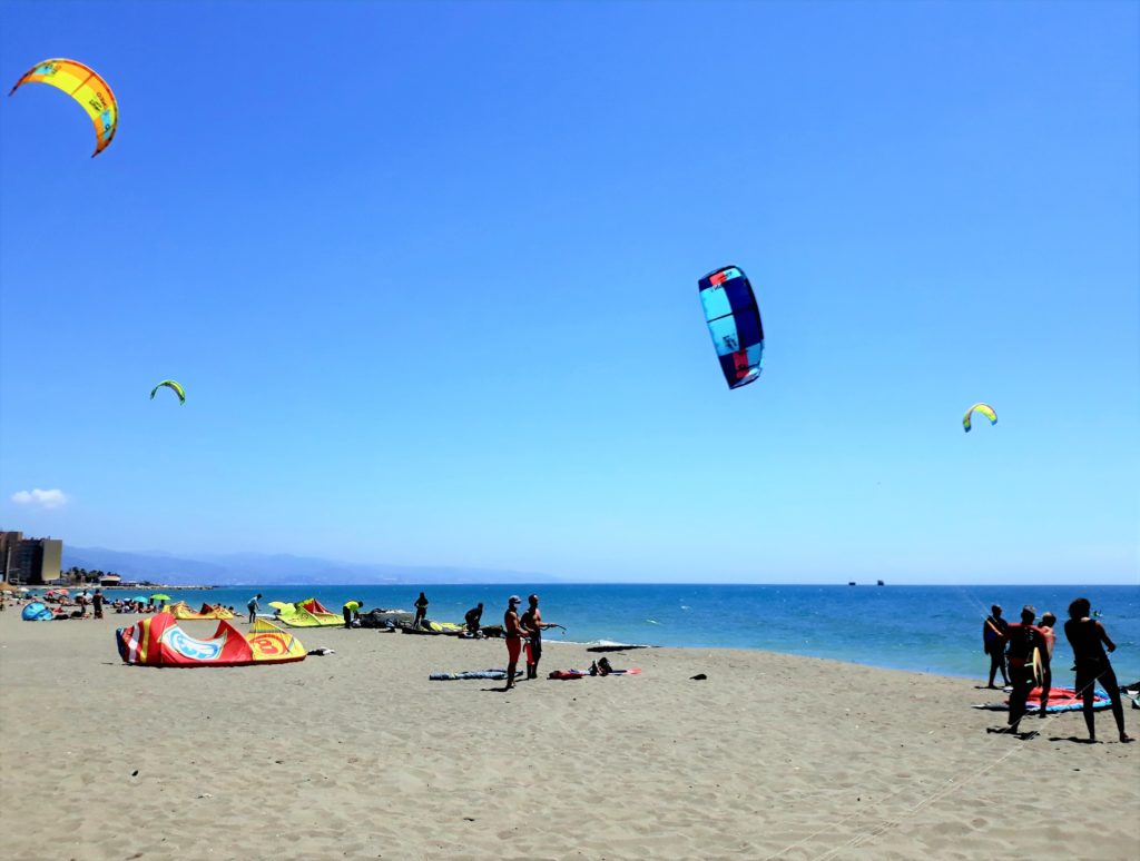 Strand mit Wassersportlern 