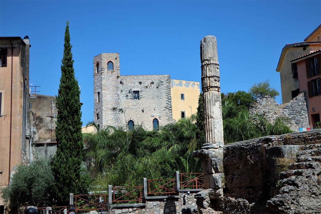 Römische Säule mit einem alten Gebäude im Hintergrund