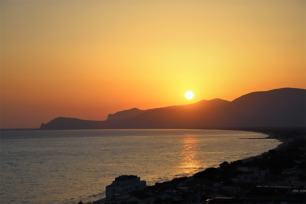 Sonnenuntergang mit knalligen Farben - hinter Bergen untergehend 