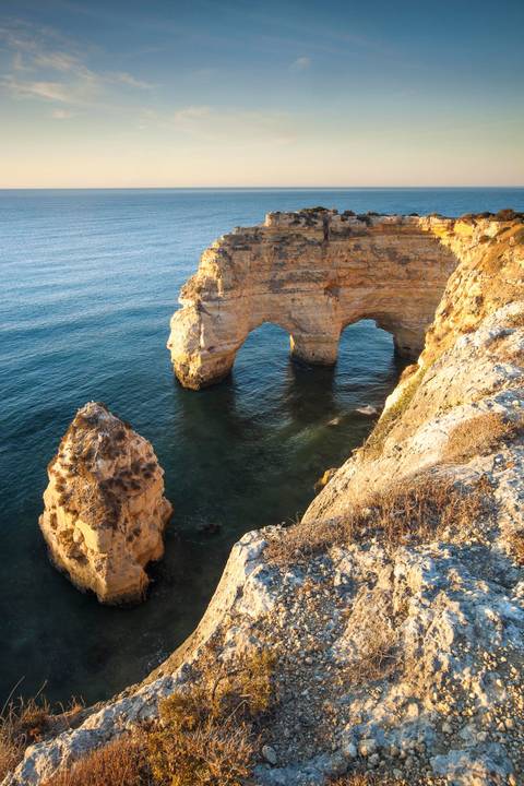 Küste an der Algarve Felsformation am Wasser blau