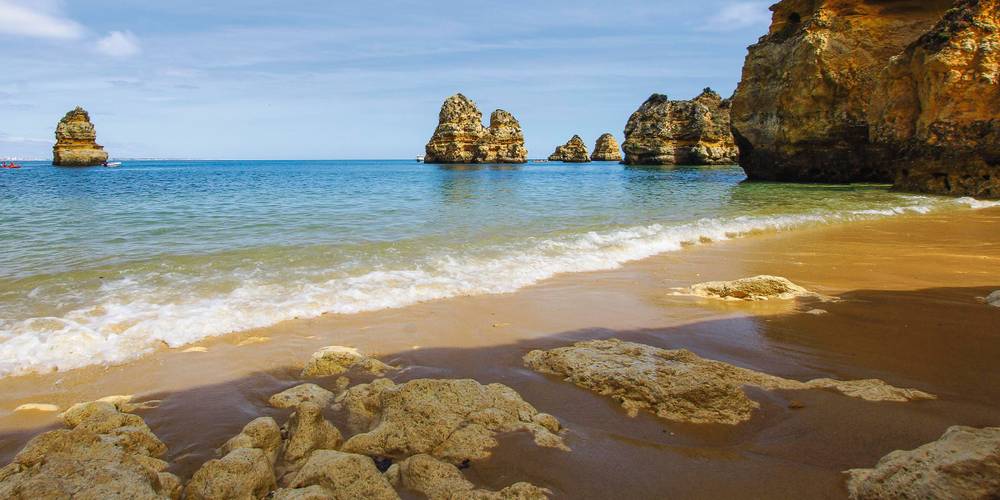 Praia do Camilo an der Algarve mit Felsen im und am Meer