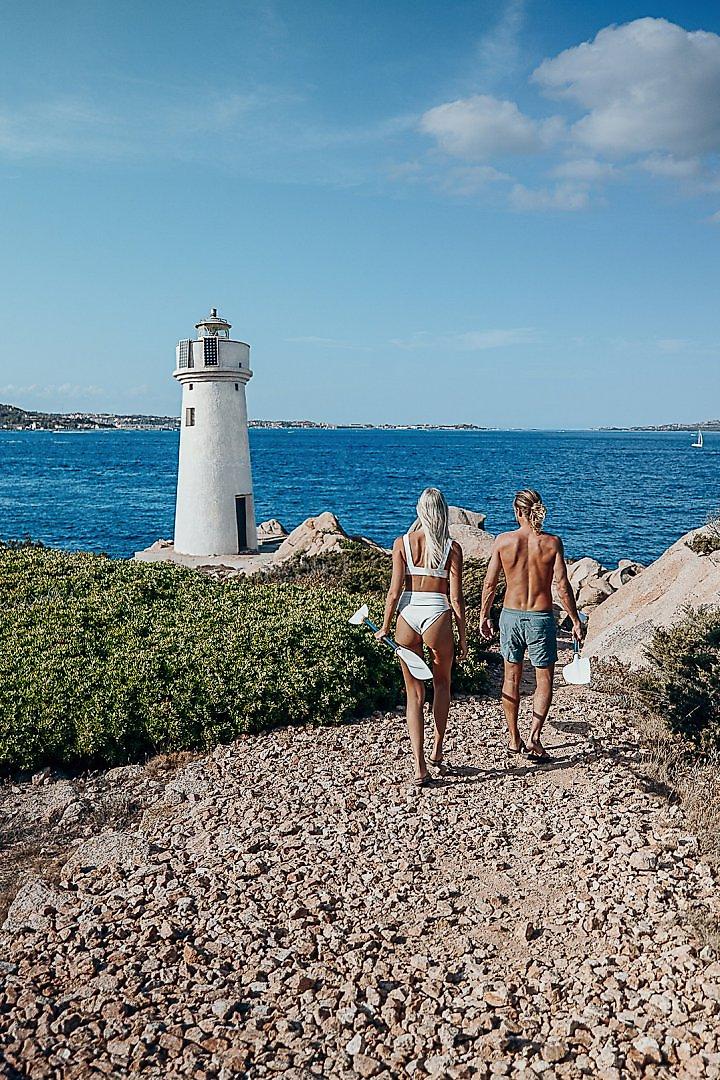 Hotel Capo D’Orso Thalasso & SPA, Historischer Leuchtturm auf einer felsigen Landzunge vor dem blauen Meer.