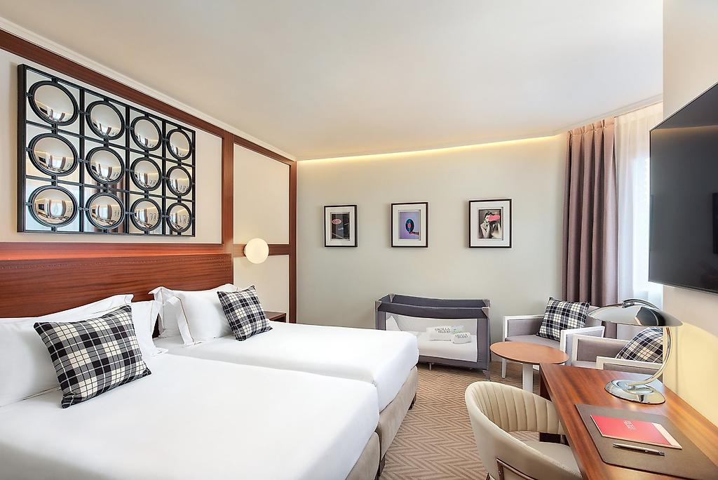 Hotel Ercilla de Bilbao Autograph Collection, Hell und freundlich gestalteter Wohnbereich eines Hotelzimmers oder einer Suite mit modernen Möbeln.