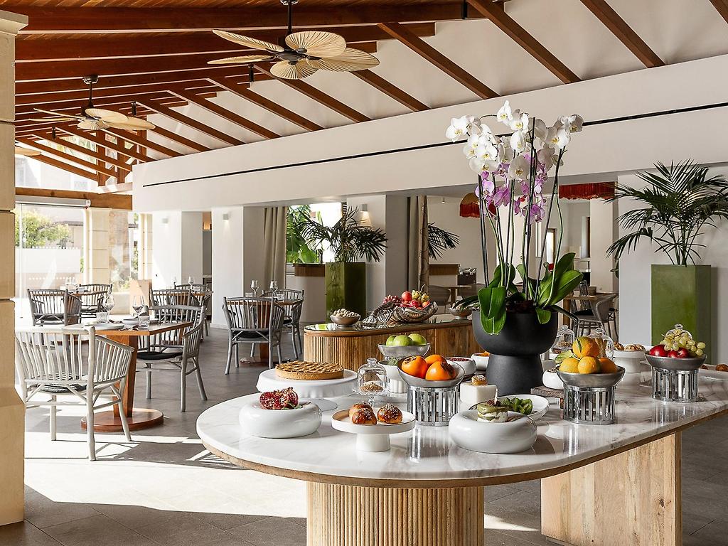 Grecotel Casa Adele, Helles Hotelrestaurant mit modernem Interieur und einladenden Sitzplätzen.