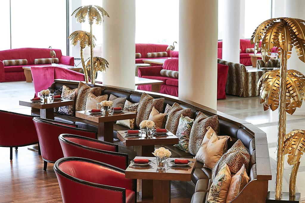Grecotel LUX®ME Dama Dama, Lichtdurchflutete Hotel-Lounge mit moderner und einladender Einrichtung.