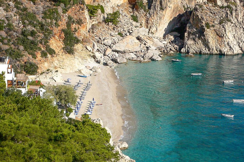Akropolis Pension, Malerischer Strandabschnitt mit feinem Sand und sanft auslaufenden Wellen an einer mediterranen Küste.