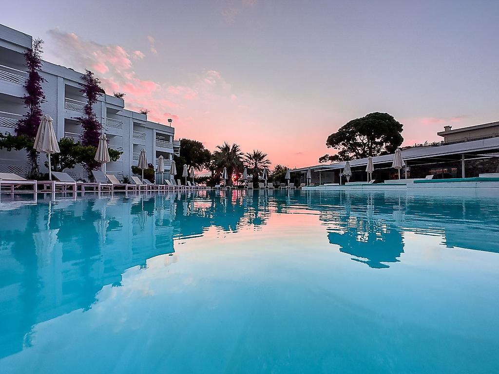 Marathon Beach Resort, Großzügige Poollandschaft des Hotels bei Athen mit Palmen und Liegebereichen.