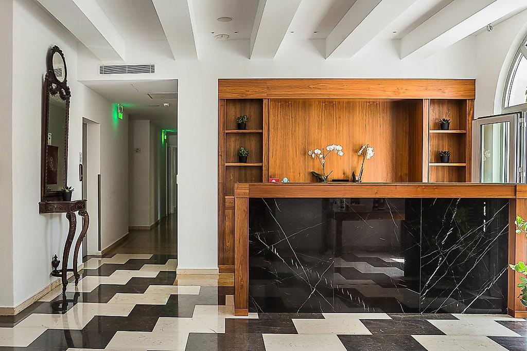 Aenos Hotel, Elegante Hotel-Lobby mit traditionellen Akzenten, gemütlichen Sitzmöbeln und hellem Boden.