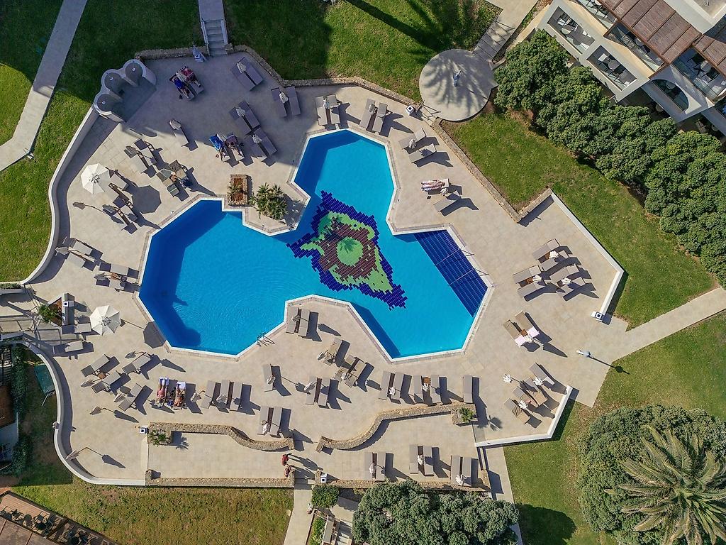 Oya Beach Resort, Detailaufnahme des klaren Poolwassers mit einladenden Sonnenliegen im Hintergrund.