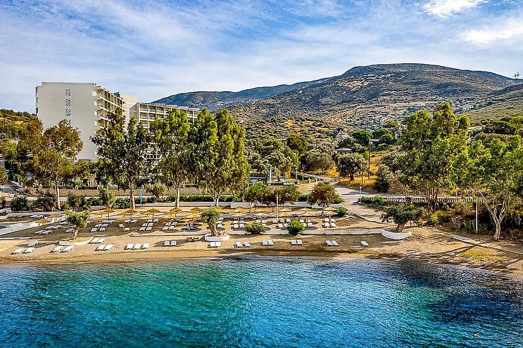 Evia Riviera Resort, Weitläufiger Sandstrand direkt vor dem Hotel mit blauem Meer und sanften Wellen.