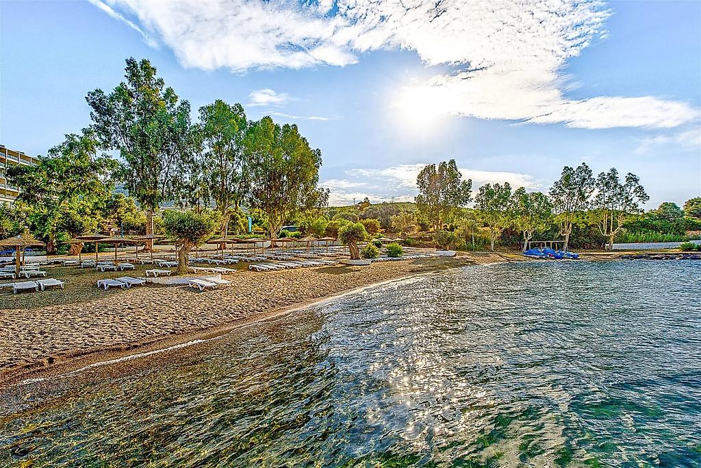 Evia Riviera Resort, Malerische Bucht mit kristallklarem Wasser und Felsformationen in Hotelnähe.
