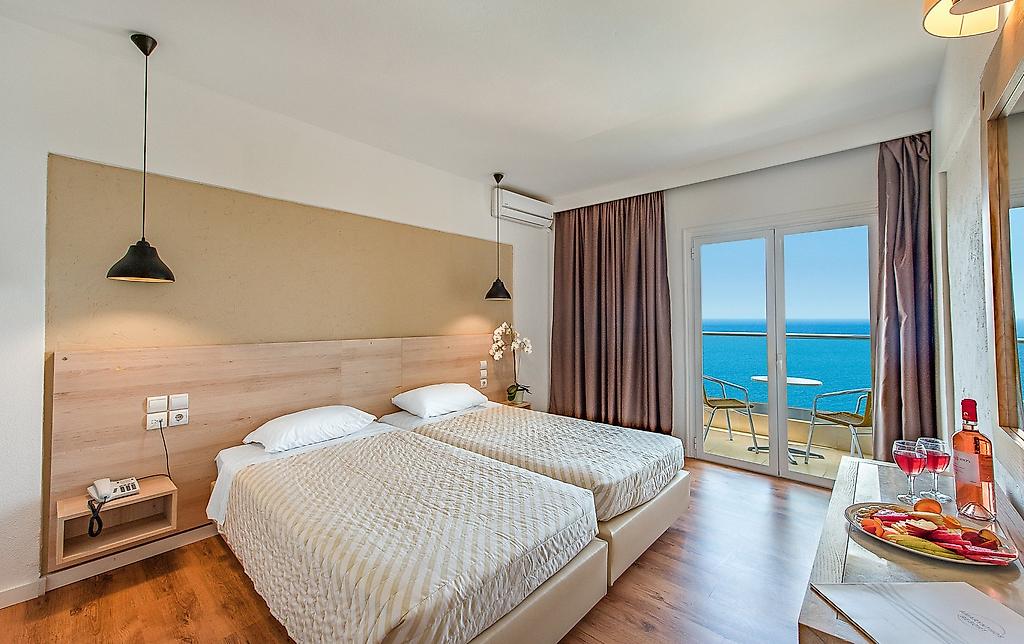 Evia Riviera Resort, Komfortables Hotelzimmer mit Doppelbett, hellen Textilien und Balkon mit Meeresbrise.