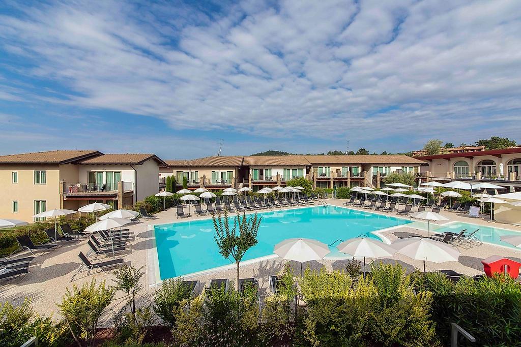 Lake Garda Resort, Einladender Swimmingpool im Außenbereich umgeben von einer gepflegten Terrasse.