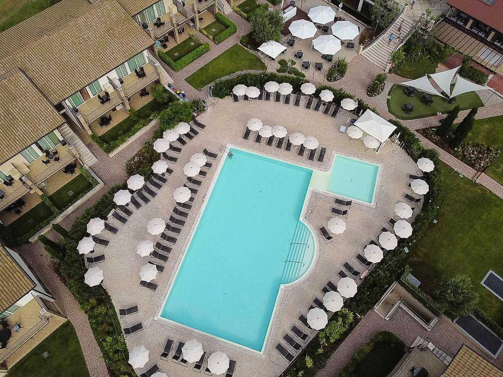 Lake Garda Resort, Luftaufnahme der großzügigen Poollandschaft des Hotels aus der Drohnenperspektive.