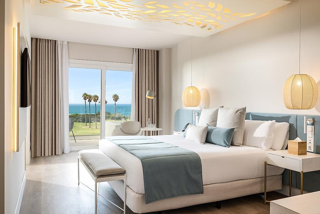 Amàre Beach Hotel Sancti Petri, Helles Doppelzimmer mit Meerblick, Doppelbett und moderner Einrichtung.