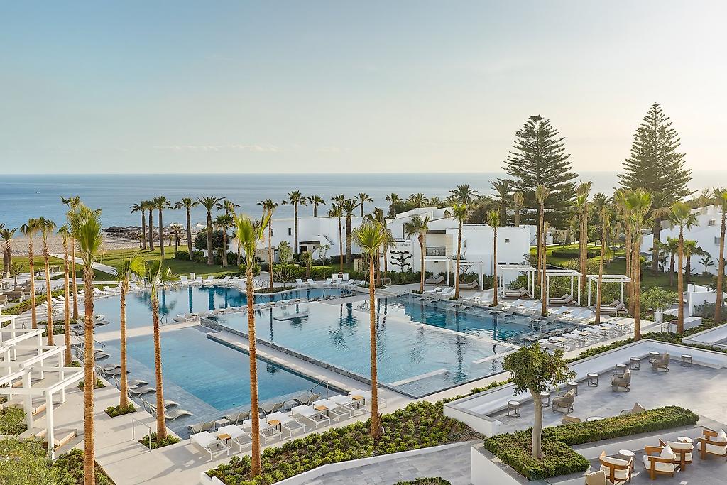Grecotel Creta Palace, Erfrischender Außenpool des Hotels, umgeben von Sonnenliegen und Sonnenschirmen.