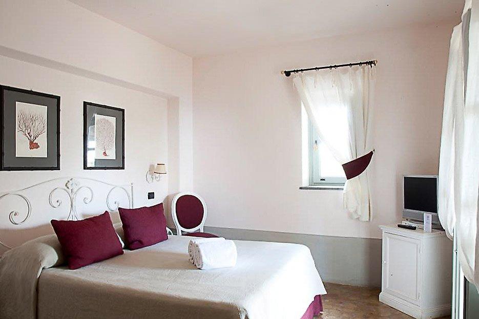 La Salina Borgo di Mare, Blick in ein freundliches Hotelzimmer mit großem Bett und geschmackvoller Dekoration.