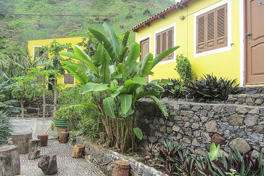 Casa das Ilhas, Detailansicht des Hotelgebäudes mit Balkonen und Steinmauern in einer trockenen, bergigen Landschaft.