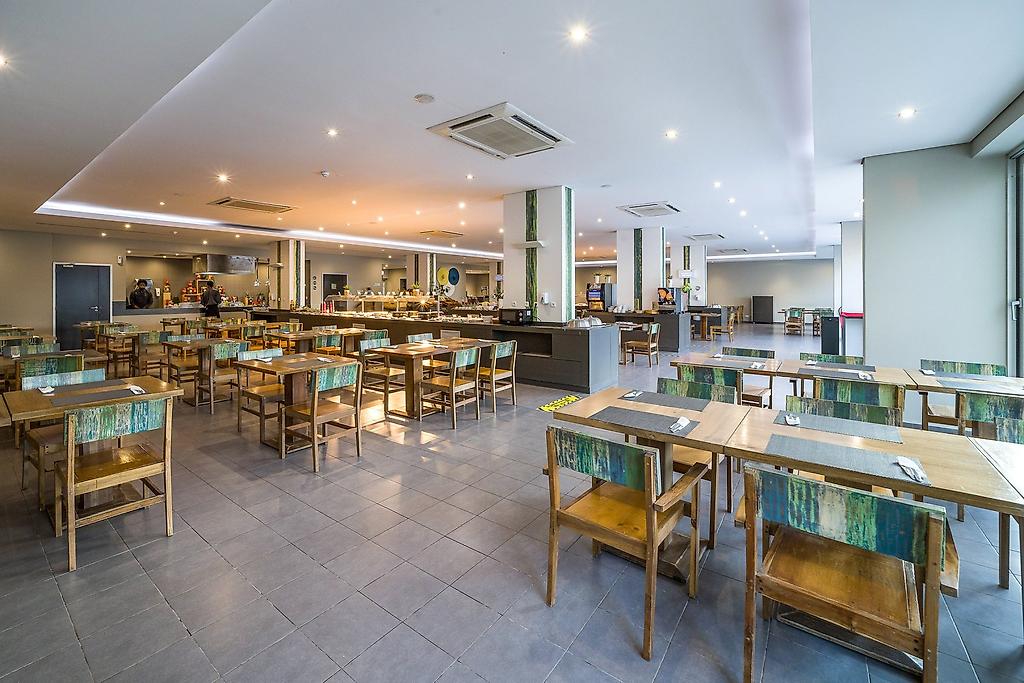 Oásis Salinas Sea, Außenbereich des Restaurants mit überdachten Sitzplätzen und Blick ins Grüne.