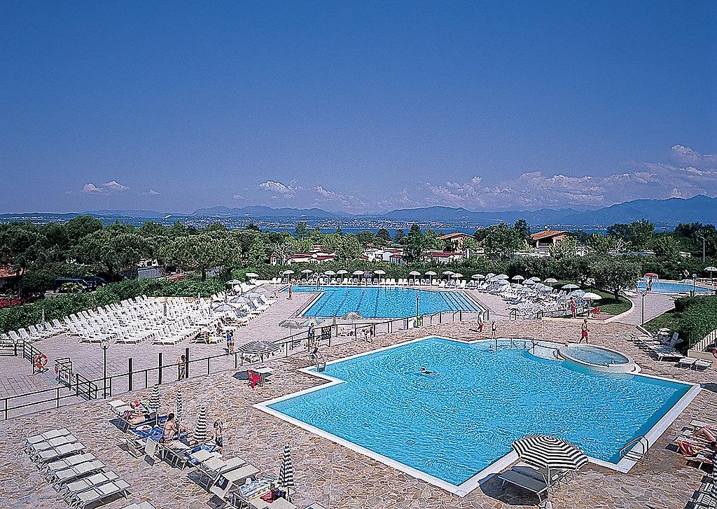 The Garda Village, Großer Poolbereich mit mehreren Becken, Sonnenterrasse und vielen Liegen.