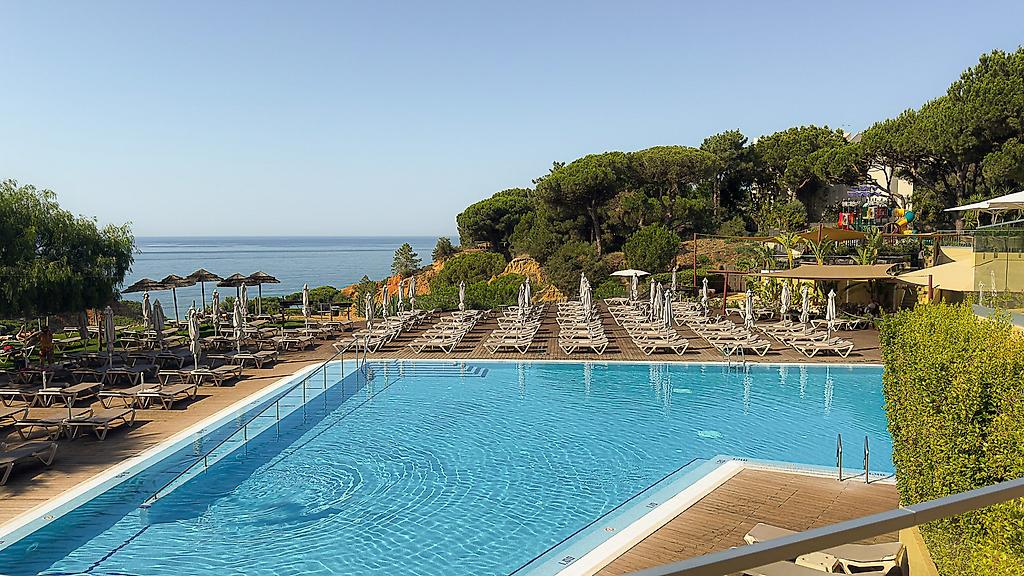 3HB Falésia Beach, Außenpoolanlage mit türkisfarbenem Wasser, umgeben von einer Sonnenterrasse mit Liegen.