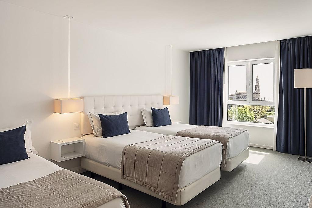 GRACE Smart Design Hotel, Wohnlicher Schlafbereich im Hotelzimmer mit funktionaler und moderner Möblierung.