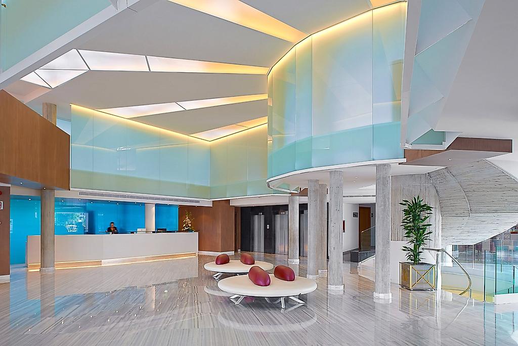 Hipotels Coma Gran, Freundliche Lobby mit Sitzbereichen und Rezeption.