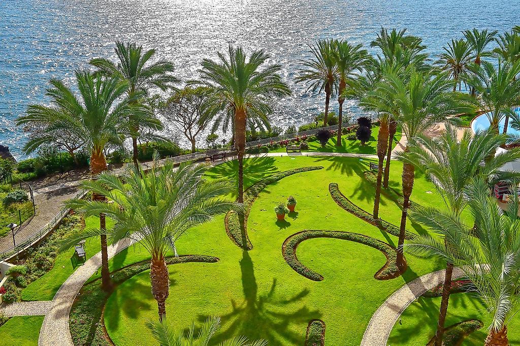 Pestana Grand – Premium Ocean Resort, Idyllische Gartenanlage mit tropischer Bepflanzung.
