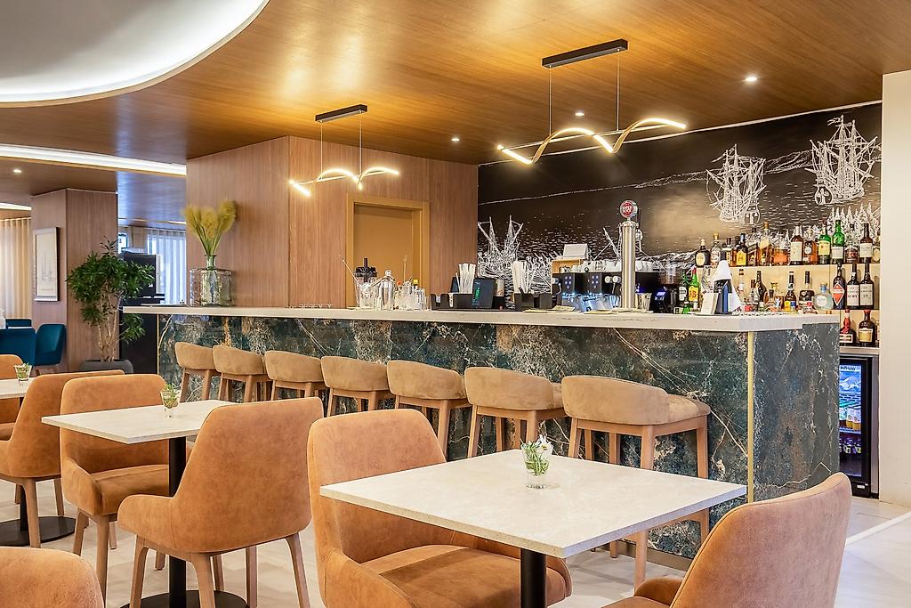 AP Sines - Costa Alentejana, Sitzbereich der Hotelbar mit eleganter Beleuchtung und Tischen.