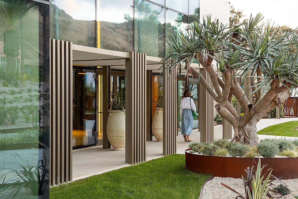 Legacy Ithos, Weitwinkelansicht des modern gestalteten Hotelgebäudes mit angrenzenden Grünflächen