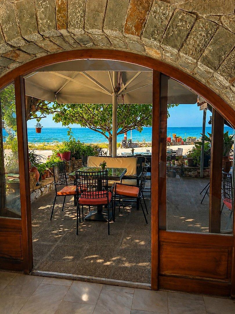 Xenios Apartments, Terrassenrestaurant im Freien mit Blick auf die umliegende Landschaft.