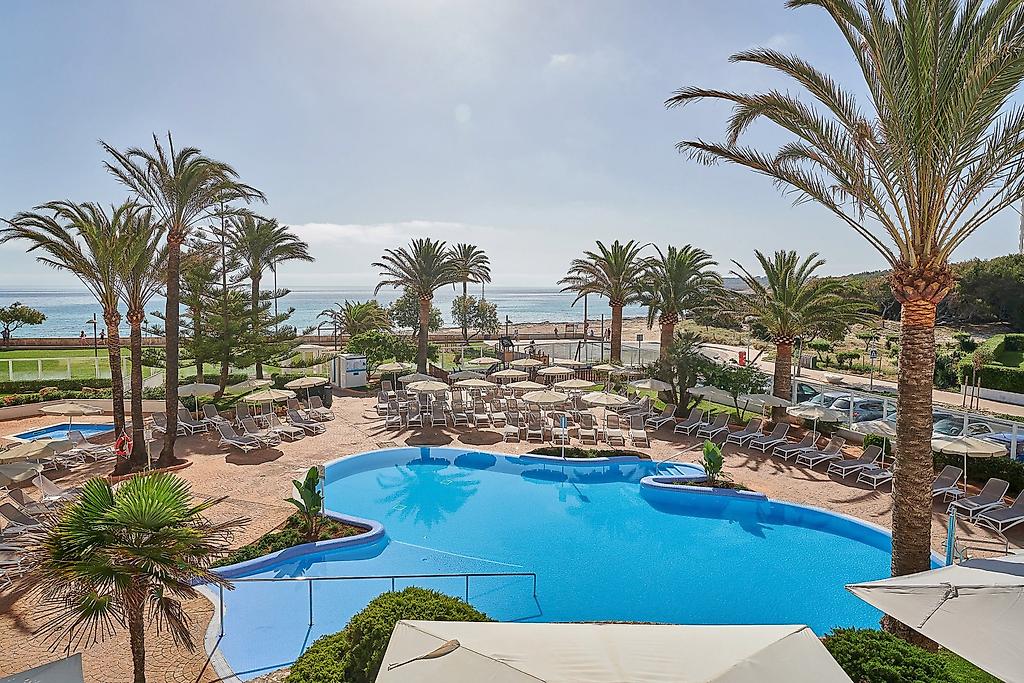 Hipotels Dunas Cala Millor, Außenpool mit Sonnenliegen und Schirmen.
