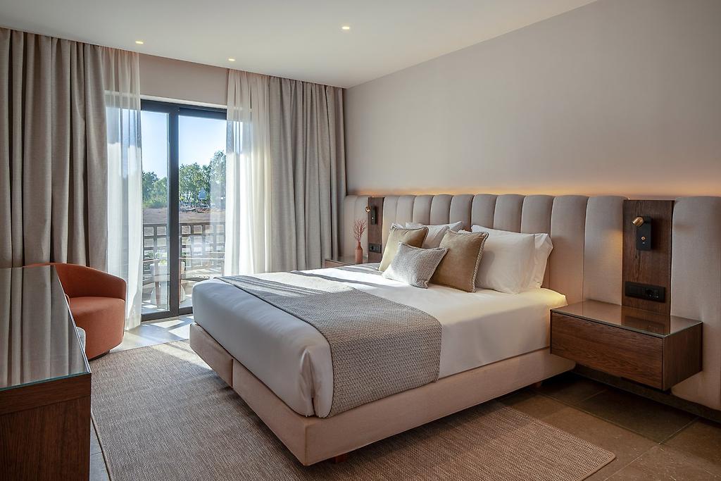 The Ritual, Helles Hotelzimmer mit gemütlichem Doppelbett, geschmackvoller Deko und Blick ins Freie.