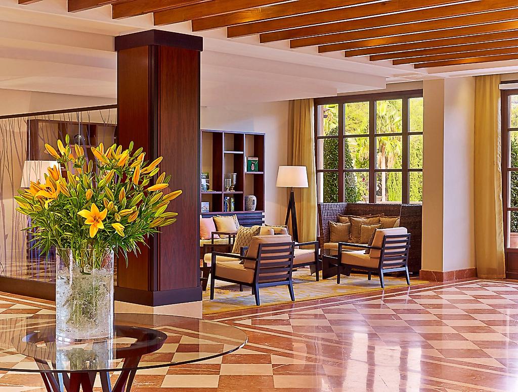 Sheraton Mallorca Arabella Golf Hotel, Moderner Rezeptionsbereich mit Empfangstresen und freundlicher Beleuchtung.