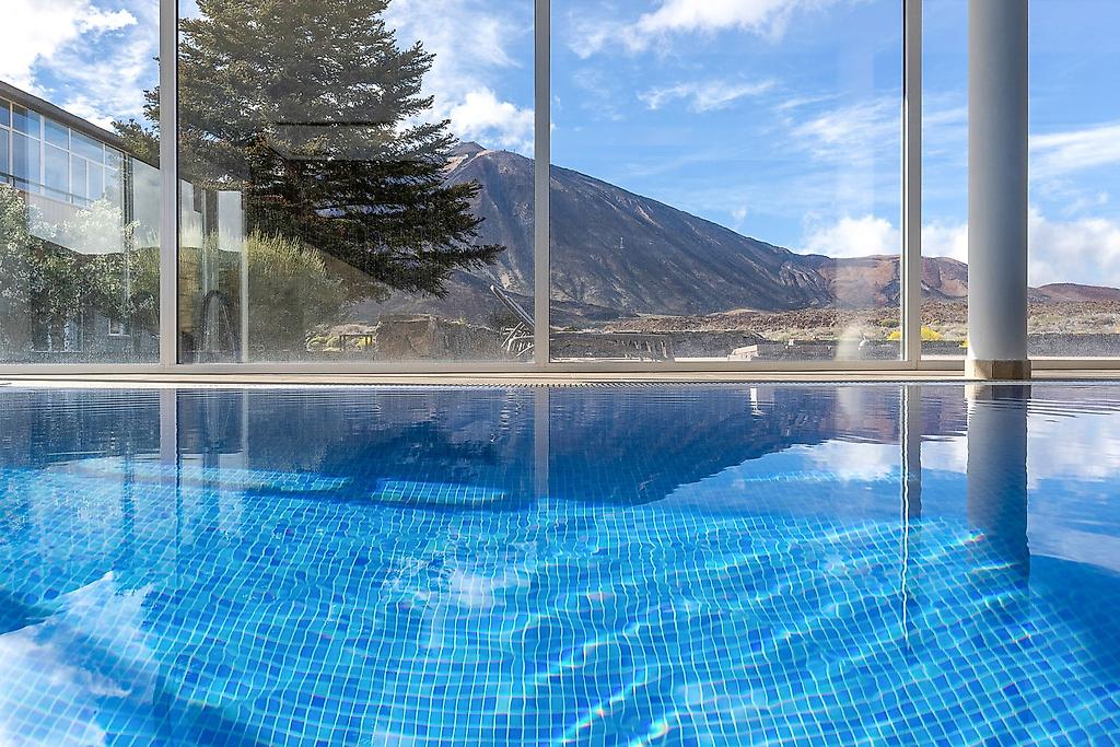 Parador Cañadas del Teide, Großzügiger Außenpoolbereich des Hotels mit klarem, blauem Wasser, umgeben von einer Sonnenterrasse mit Liegestühlen und Schirmen zum Entspannen.
