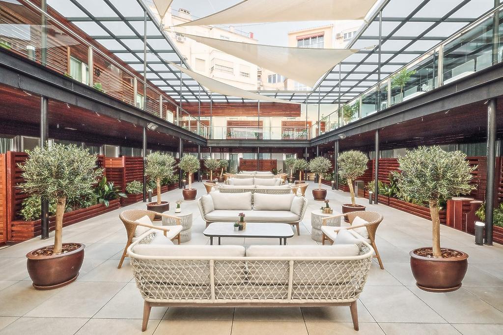 Hospes Palau de la Mar, Traditioneller oder moderner Innenhof (Patio) des Hotels mit Sitzgelegenheiten und Pflanzen, der zum Verweilen einlädt.