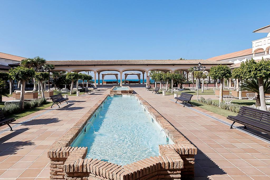 Iberostar Selection Andalucía Playa, Gepflegte Gartenanlage des Hotels nahe Jerez mit Palmen
