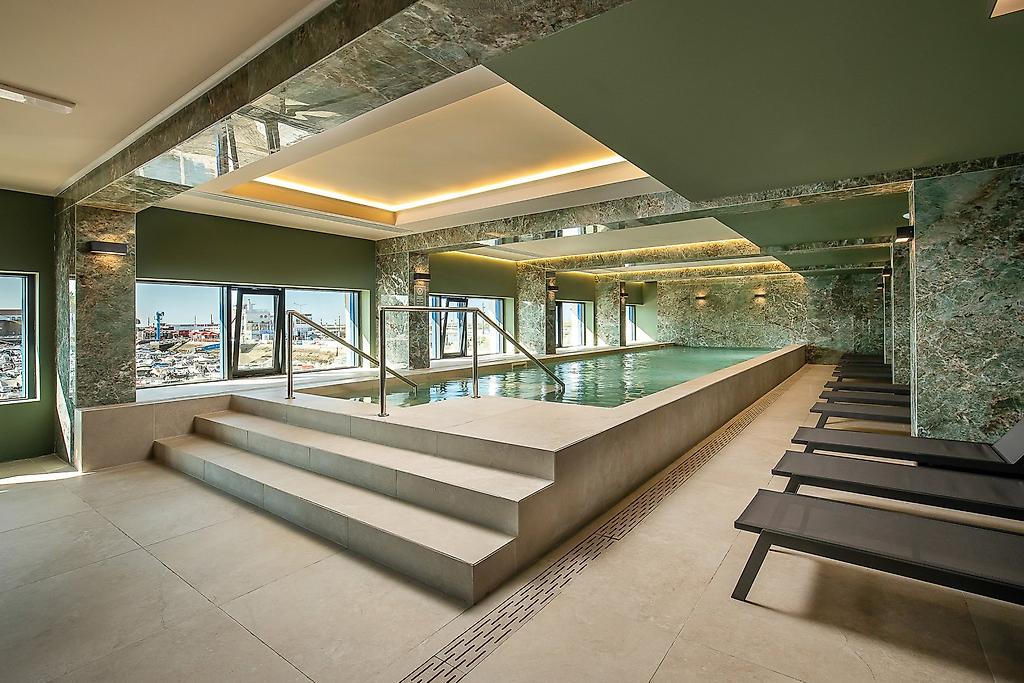 AP Eva Senses Hotel, Moderner Hotel Innenpool in Portugal mit Liegen und hellem Wellnessbereich